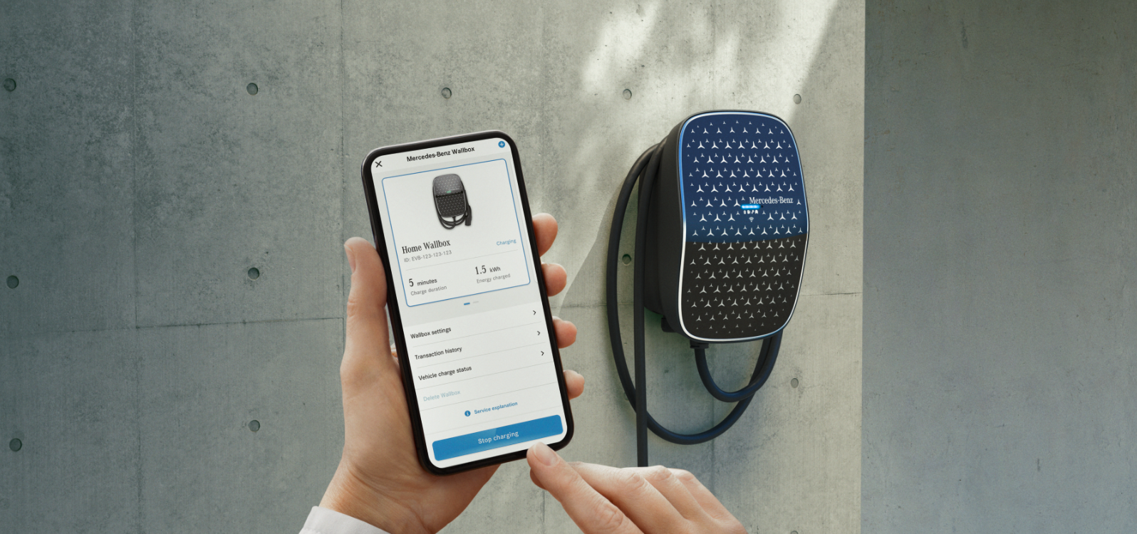 Instalación de la Mercedes-Benz Wallbox Una mano sosteniendo un smartphone para controlar la Mercedes-Benz Wallbox.