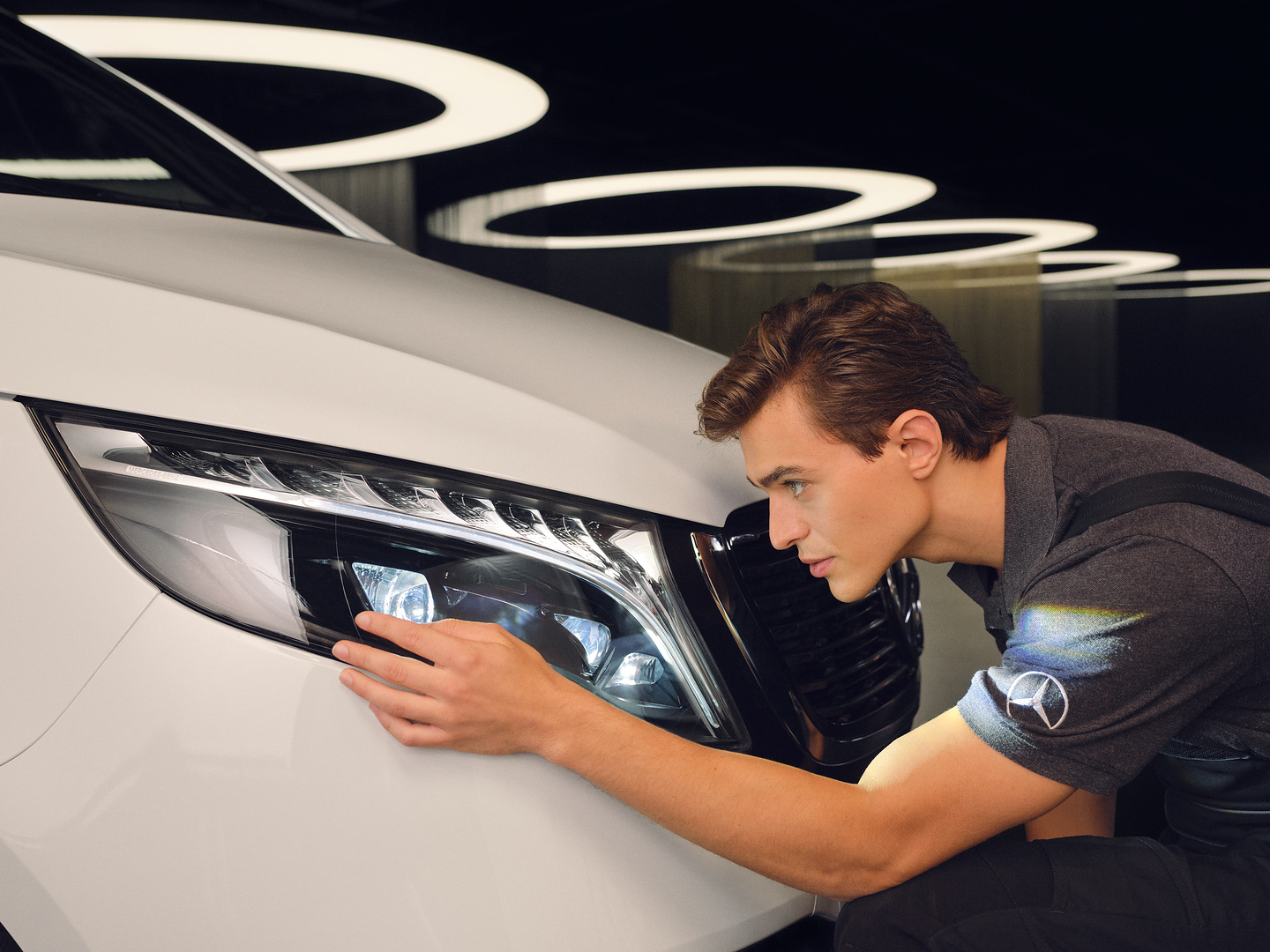 SmallRepair | Mercedes-Benz Un técnico de servicio posventa examina los faros de un Mercedes.
