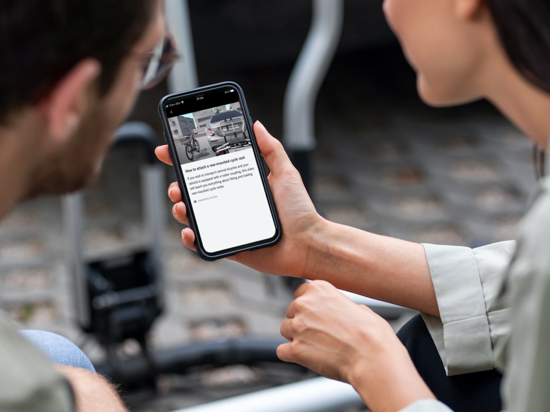 Un hombre y una mujer mirando tutoriales en el smartphone.