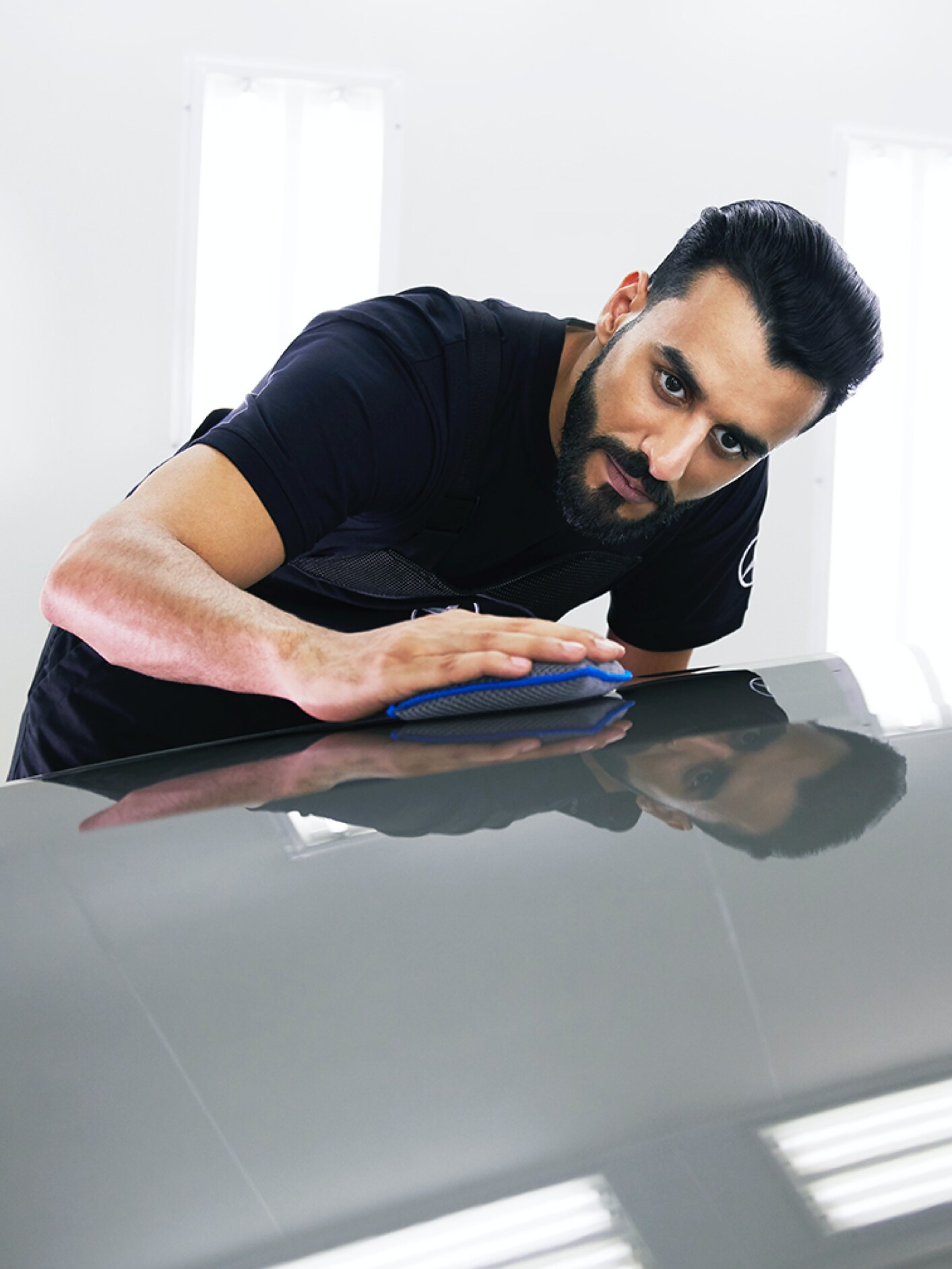 Un técnico de Mercedes-Benz examina el capó en busca de pequeños desperfectos.