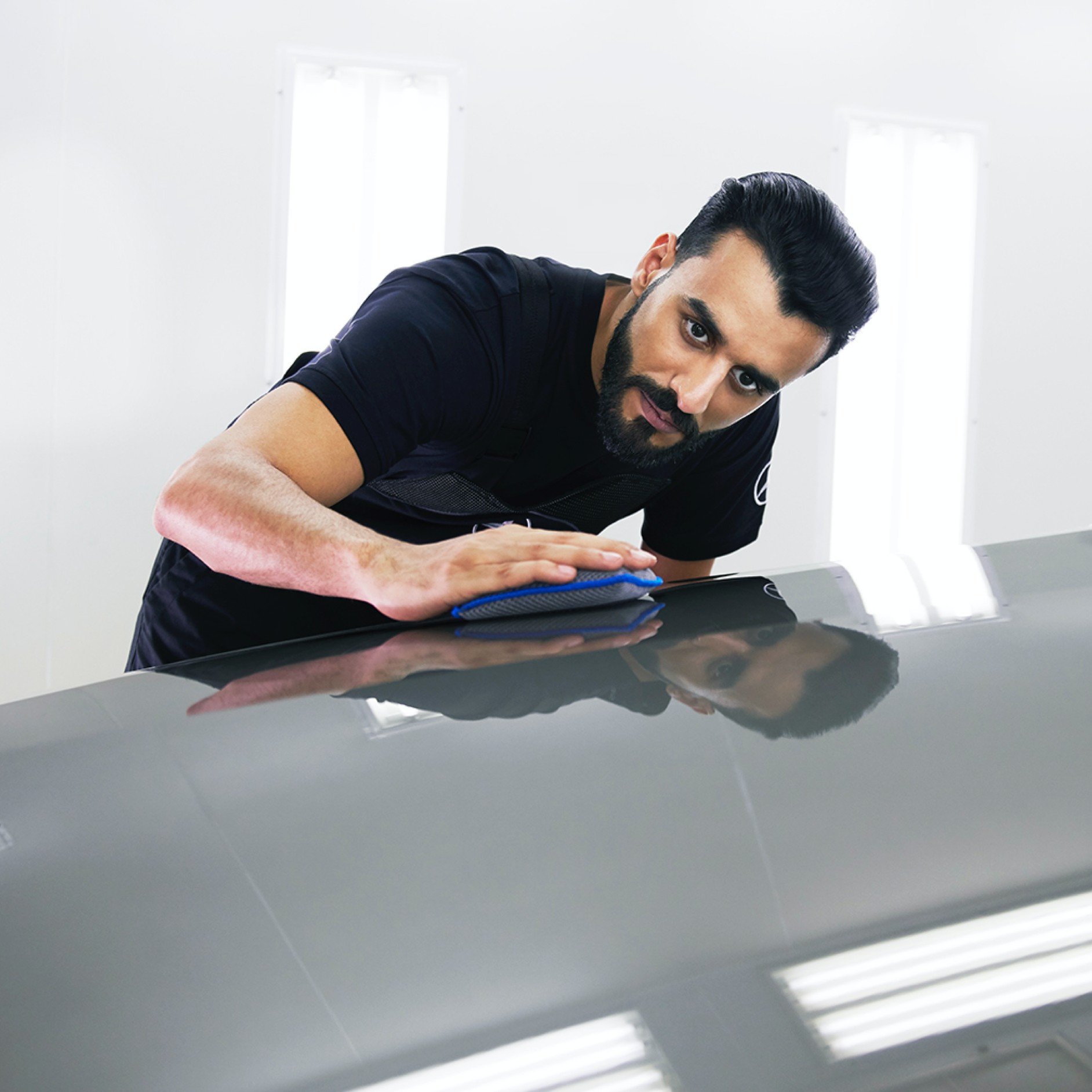 SmallRepair Un técnico de Mercedes-Benz examina el capó en busca de pequeños desperfectos.