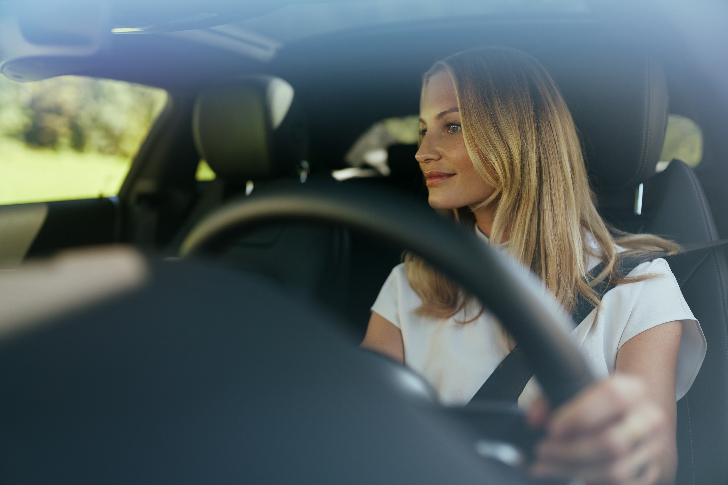 Disfruta de tu vehículo con la tranquilidad que te da la garantía Mercedes-Benz. | Mercedes-Benz Una mujer de aspecto relajado, al volante de su Mercedes.