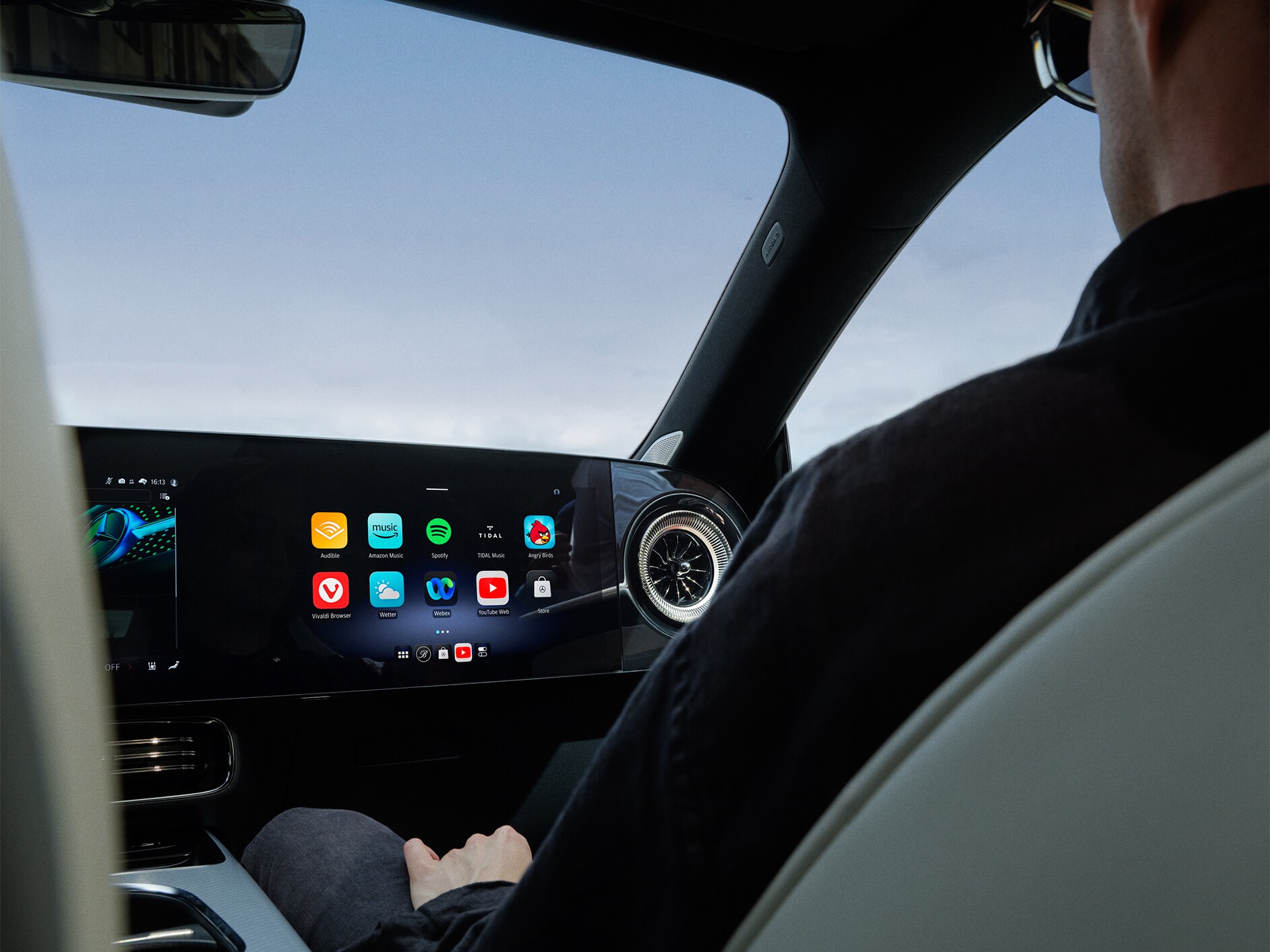 Vista del interior mostrando el puesto de conducción de un Mercedes-Benz con el sistema multimedia MBUX.