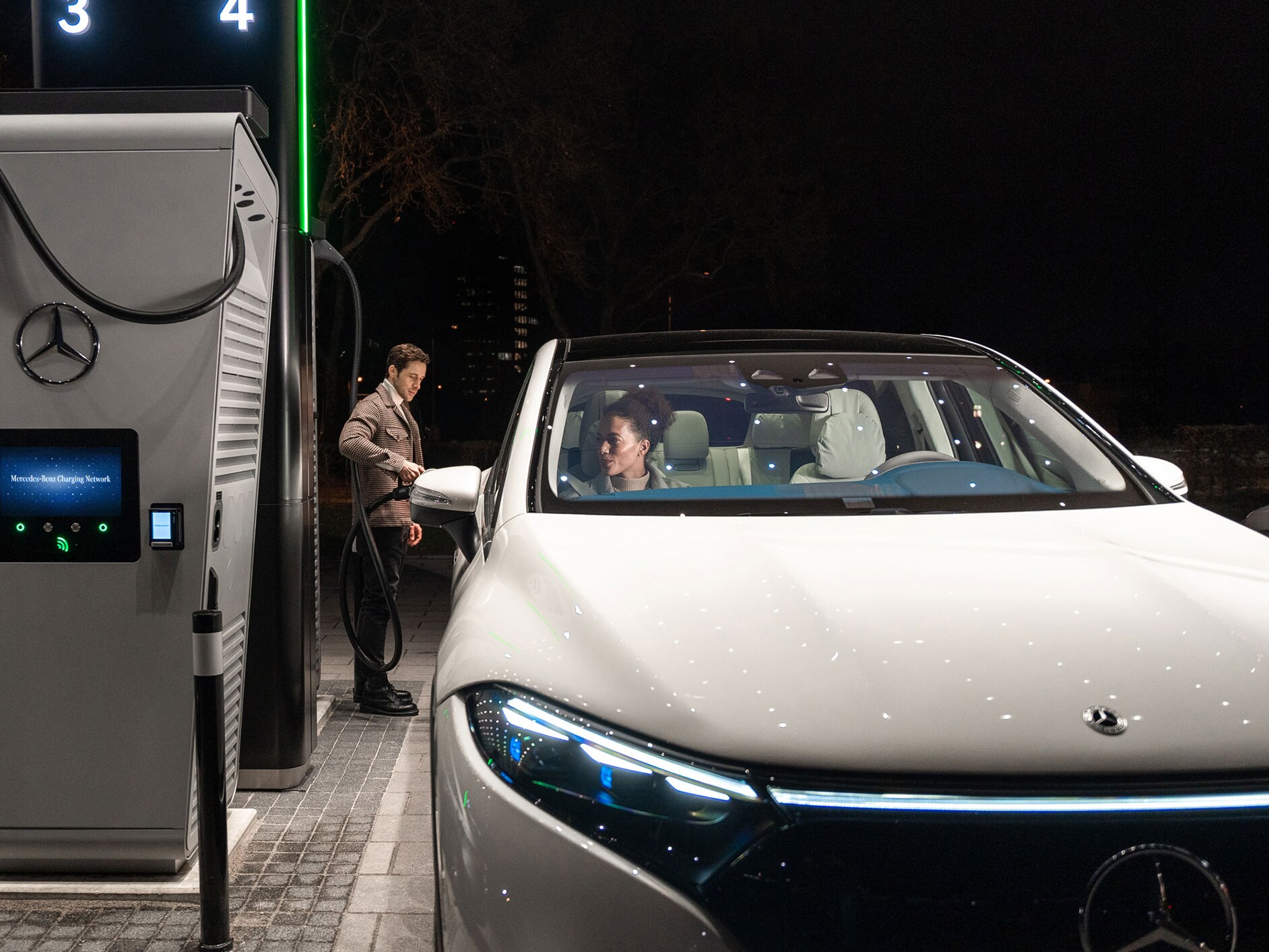 Un Mercedes-Benz CLA en una calle, conectado a una estación de carga.