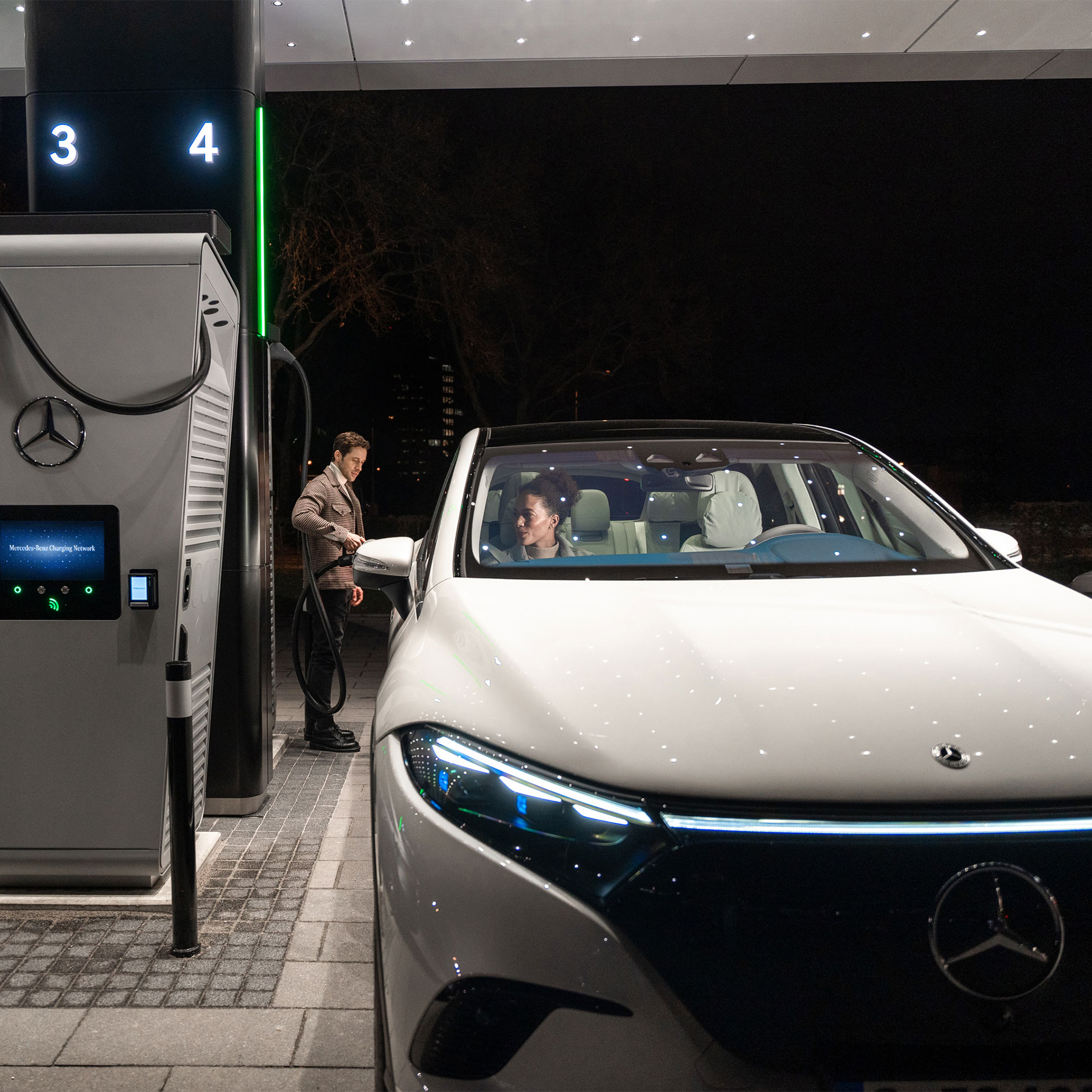 Soluciones de carga | Tecnología | Mercedes-Benz Un Mercedes-Benz CLA en una calle, conectado a una estación de carga.