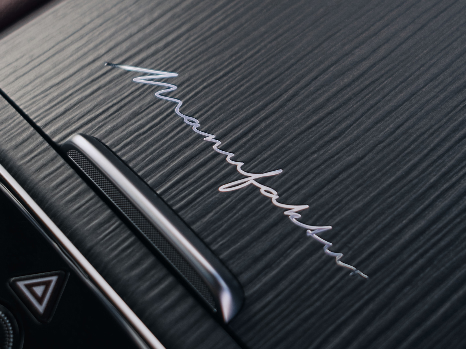 Inscripción MANUFAKTUR | Mercedes-Benz Inscripción MANUFAKTUR en el habitáculo de un vehículo.