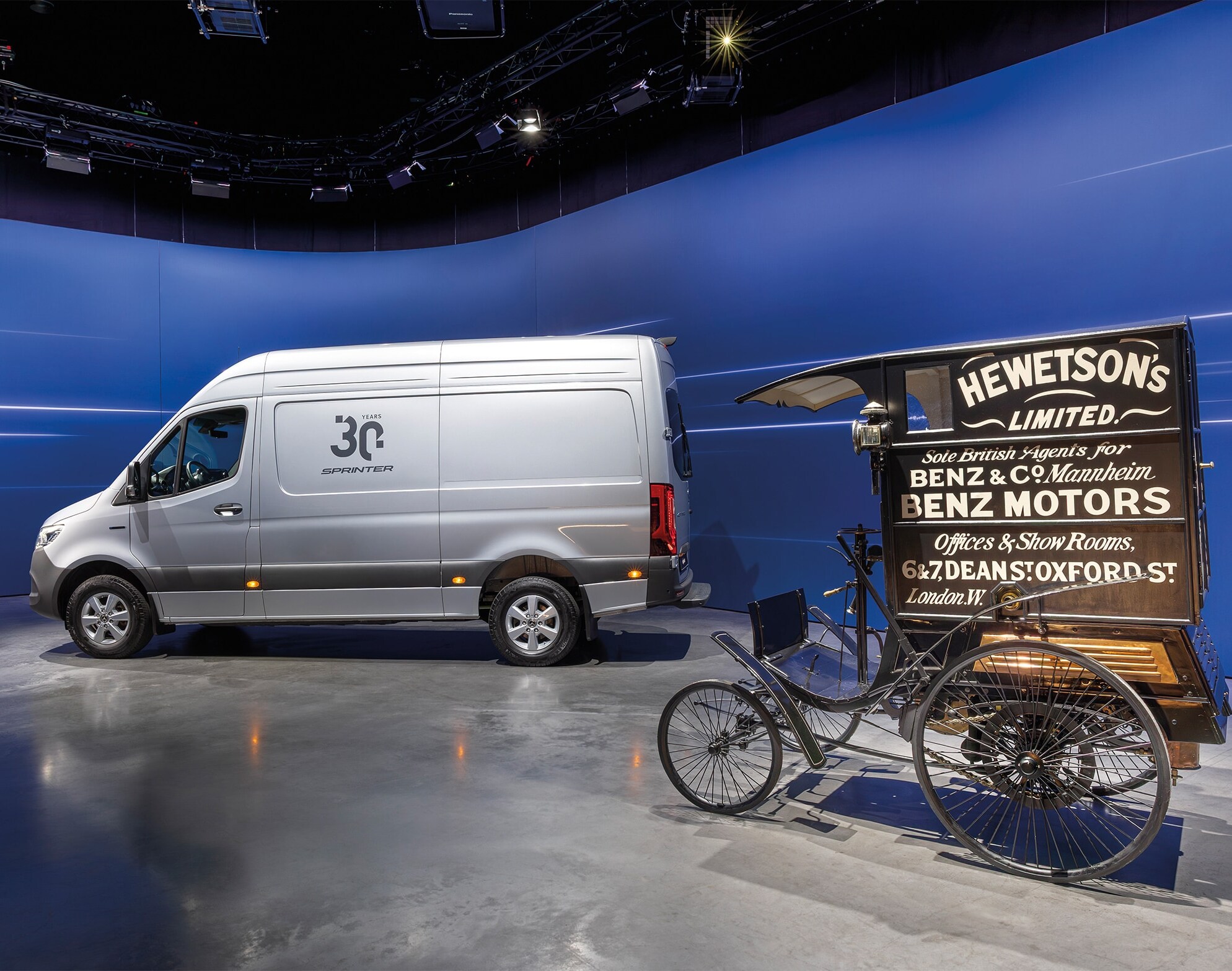 Una Van Mercedes-Benz Sprinter y un histórico vehículo de reparto de Benz expuestos en una moderna sala de exposición