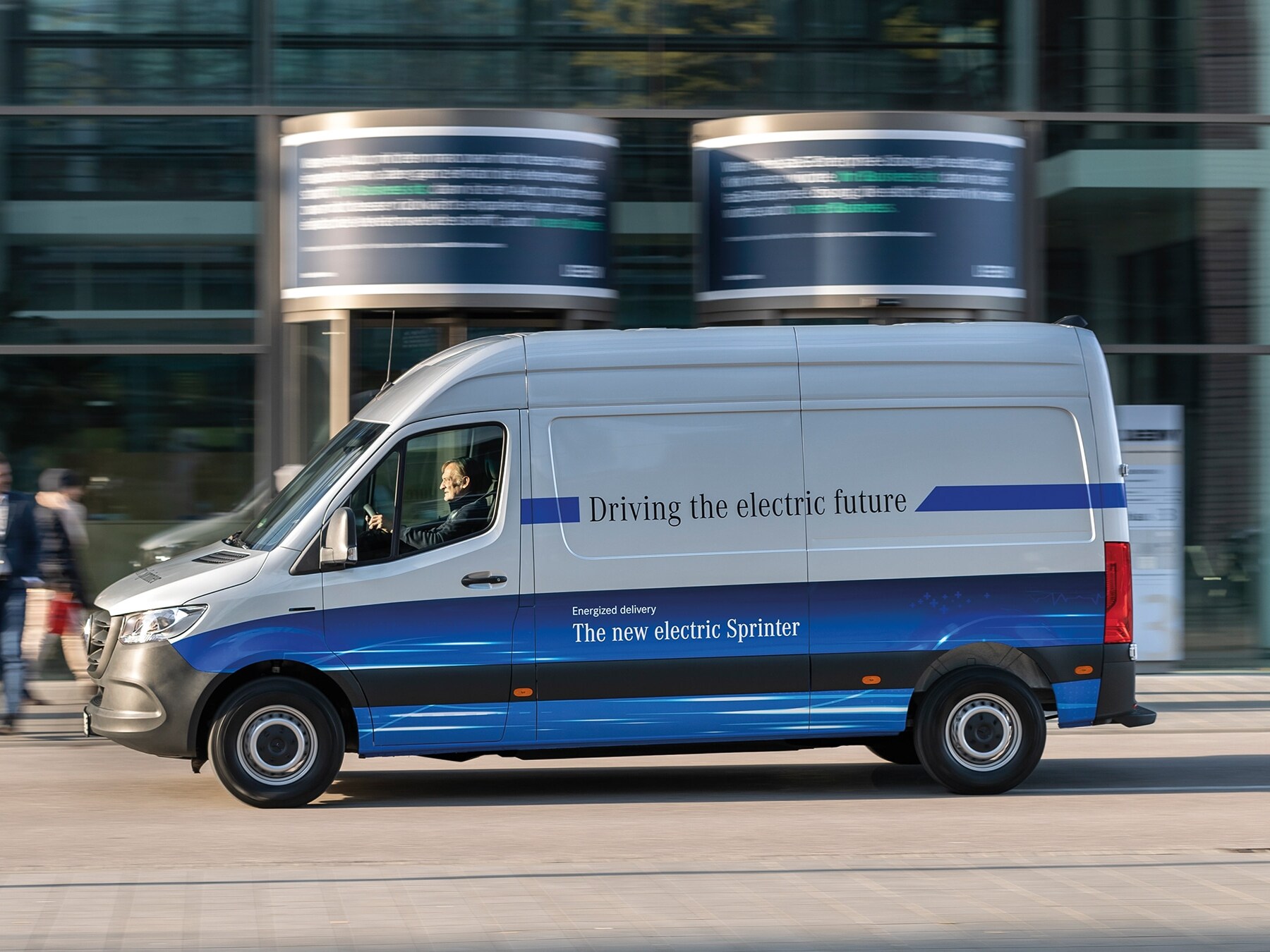 Vanes de reparto Mercedes-Benz eSprinter Panel Van circulando por una calle de una ciudad moderna