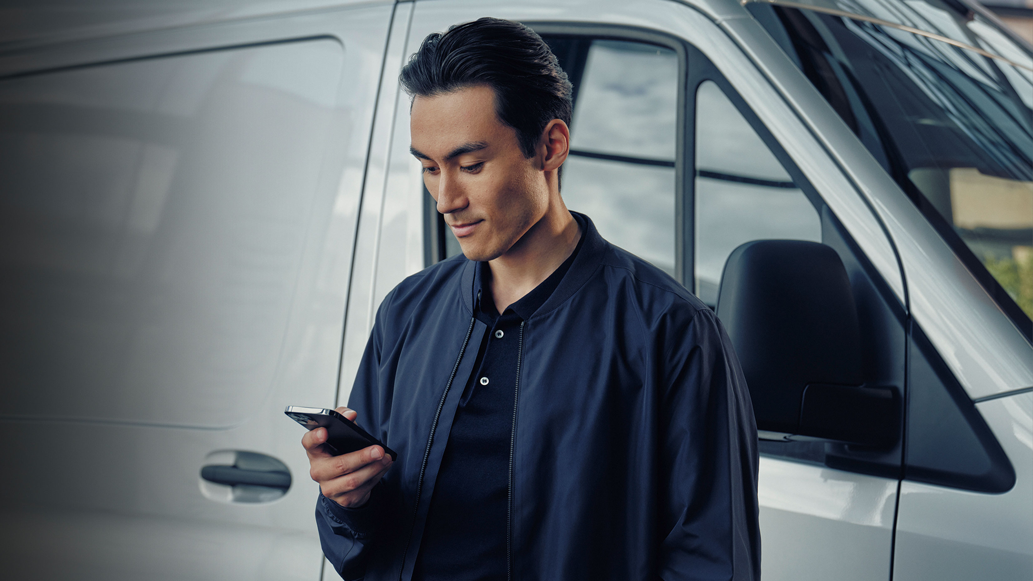 Cargar la batería en casa | Carga | Mercedes-Benz Vans Usuario chequeando su Mercedes-Benz App