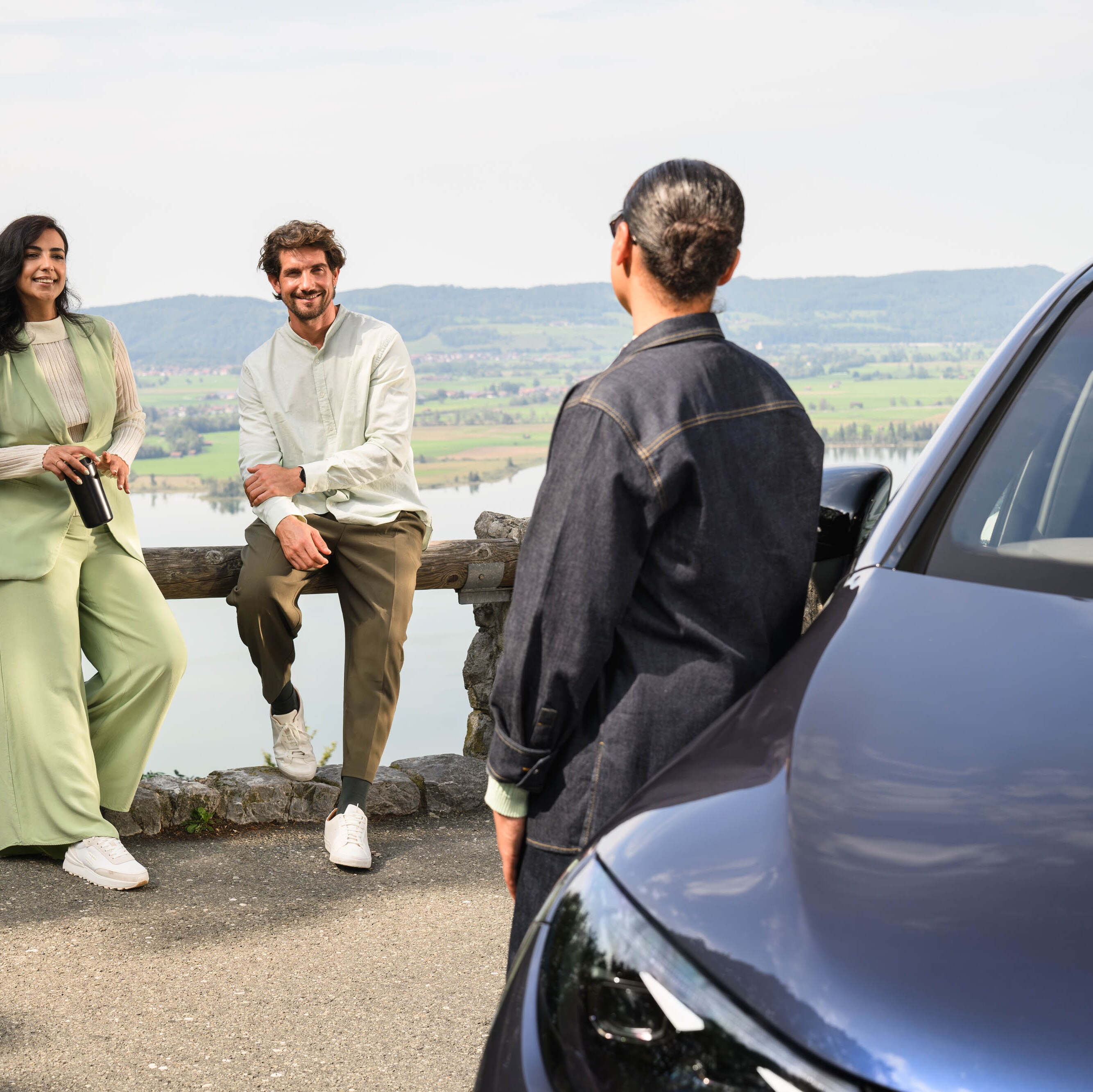 Tres personas platicando y de fondo Mercedes-Benz​