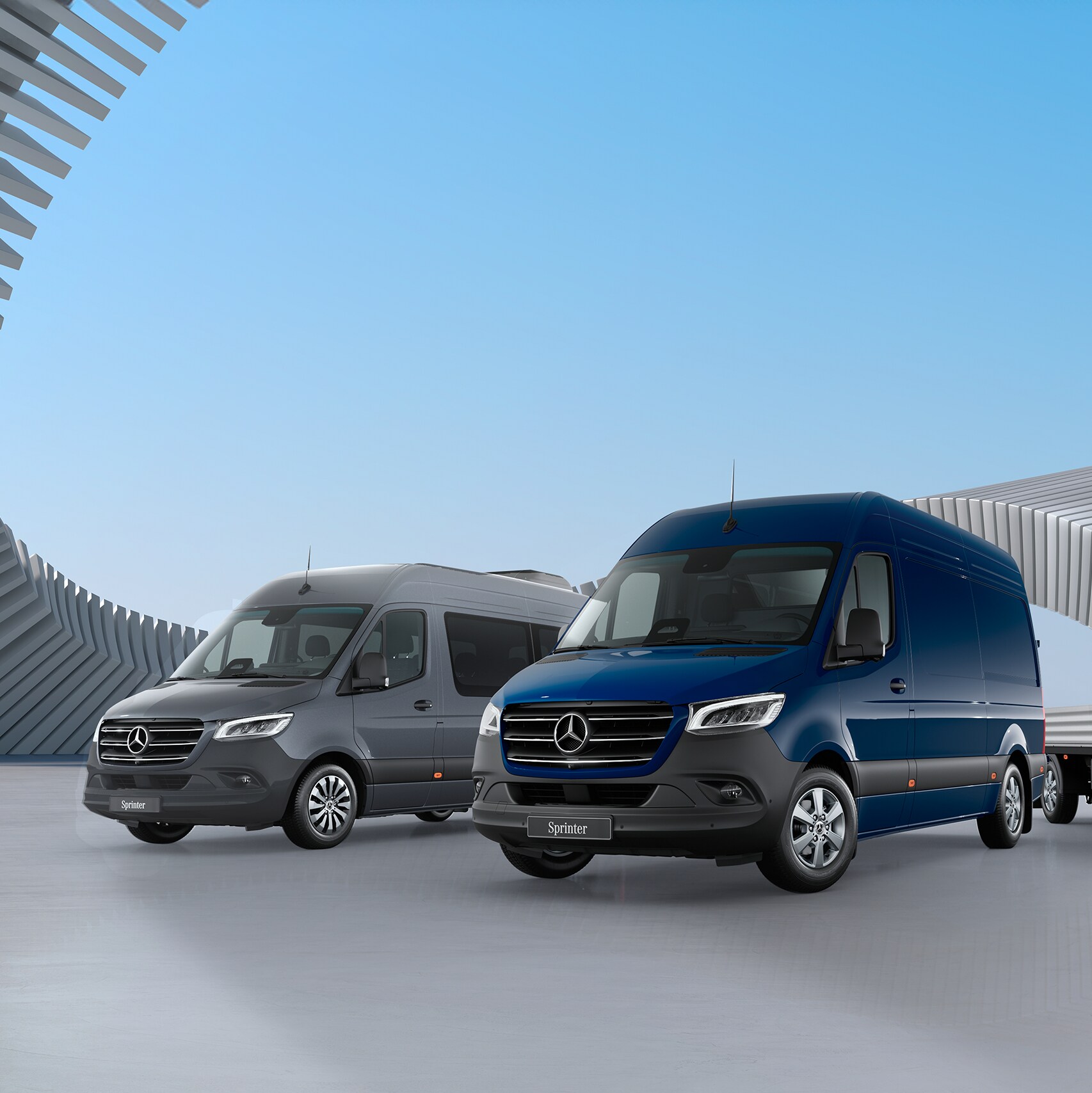 Las Sprinter Chasis y Cargo Van de Mercedes-Benz están estacionadas una junto a otra delante de un moderno conjunto de edificios.